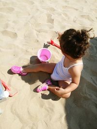 High angle view of baby girl playing with toys at beach