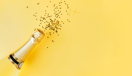 Close-up of yellow bottle against white background