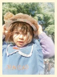 Portrait of cute girl wearing hat against trees