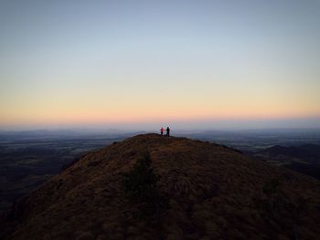 People on mountain against sky during sunset