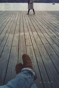 Low section of man standing on pier