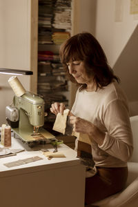 Caucasian brunette woman sewing fabric with a vintage, retro sewing machine. fashion, creation