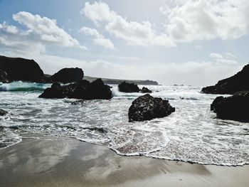 Rocks on beach against sky