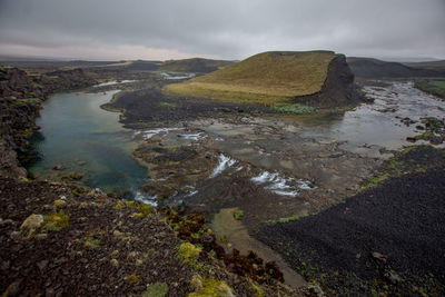 Scenic view of land and sea against sky