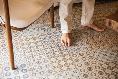 Low section of man standing on tiled floor