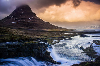 Scenic view of mountains against cloudy sky