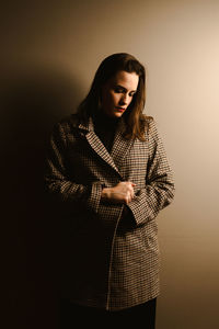 Young woman standing against gray background