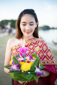 Beautiful young woman holding flower bouquet