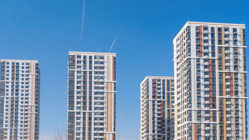 Low angle view of modern buildings against clear blue sky