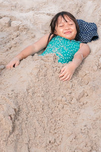 Portrait of girl lying on sand