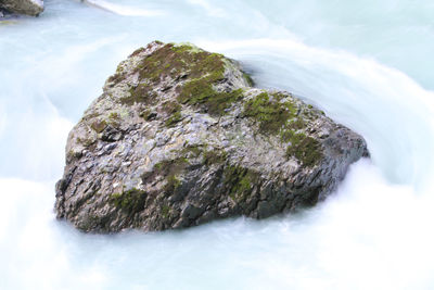 Close-up of rock formation in sea against sky
