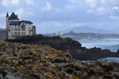 Scenic view of sea by buildings against sky