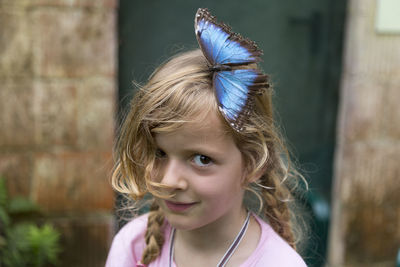Portrait of smiling girl with butterfly on her head