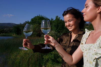 Happy friends drinking glass