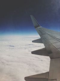 Cropped image of airplane against blue sky