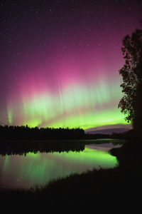 Scenic view of lake against sky at night