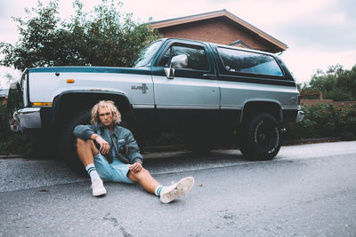 Portrait of man driving car on road in city