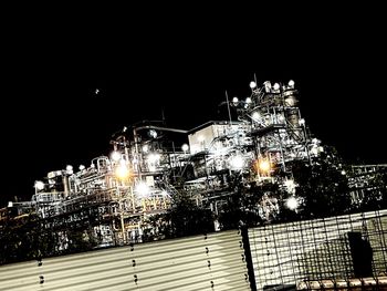 Low angle view of illuminated buildings against sky at night