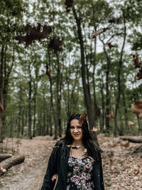 Portrait of smiling woman standing in forest