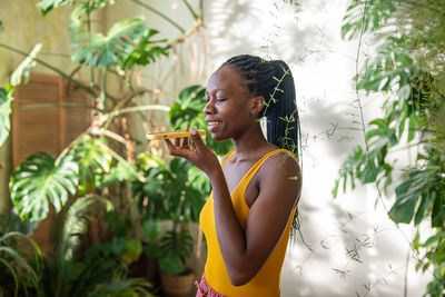 Side view of young woman drinking water