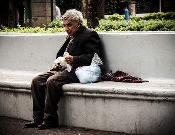 Full length of man sitting outdoors