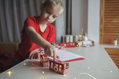 Boy playing with toy blocks on table