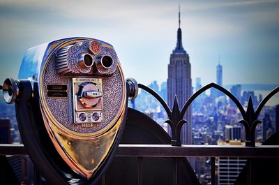 Coin-operated binoculars at railing against empire state building