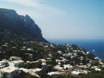 Aerial view of townscape by sea against sky