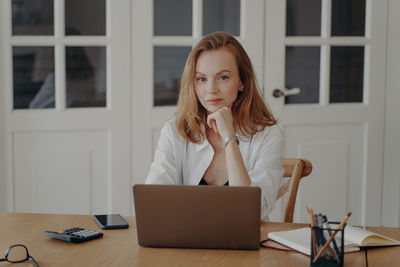 Young woman using laptop at home