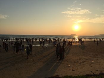 Group of people on beach at sunset