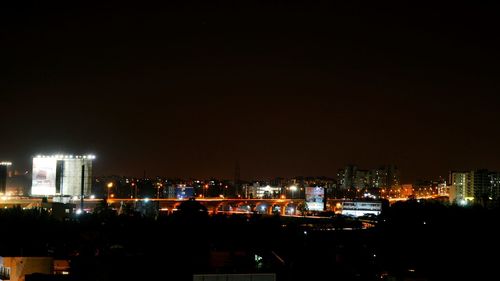 Illuminated cityscape against sky at night