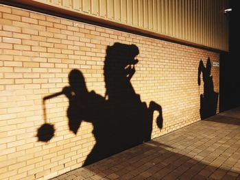 Silhouette children shadow on brick wall