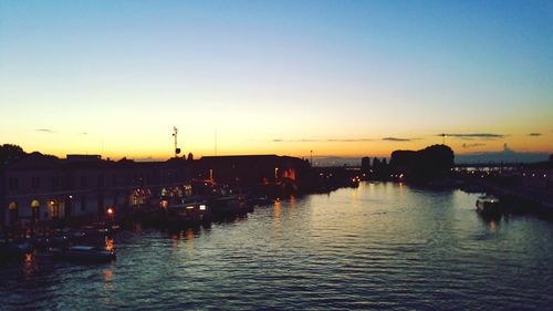 Silhouette of boats at harbor during sunset