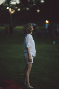 Woman standing on field at night