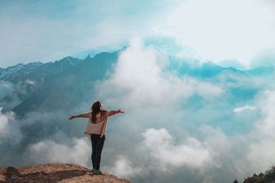 Rear view of woman standing in mountains 