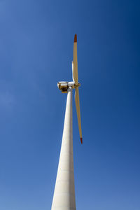 Low angle view of windmill against clear blue sky