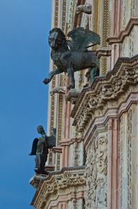 Statue on exterior wall of building