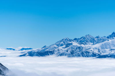 Scenic view of snowcapped mountains against clear blue sky