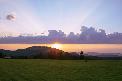 Scenic view of field against sky during sunset