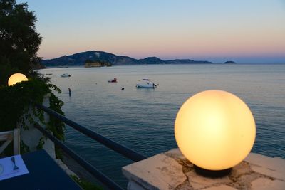 Boats in sea at sunset