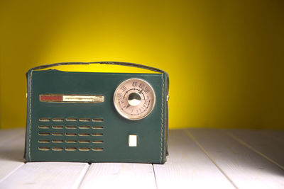 Close-up of telephone booth on table against wall