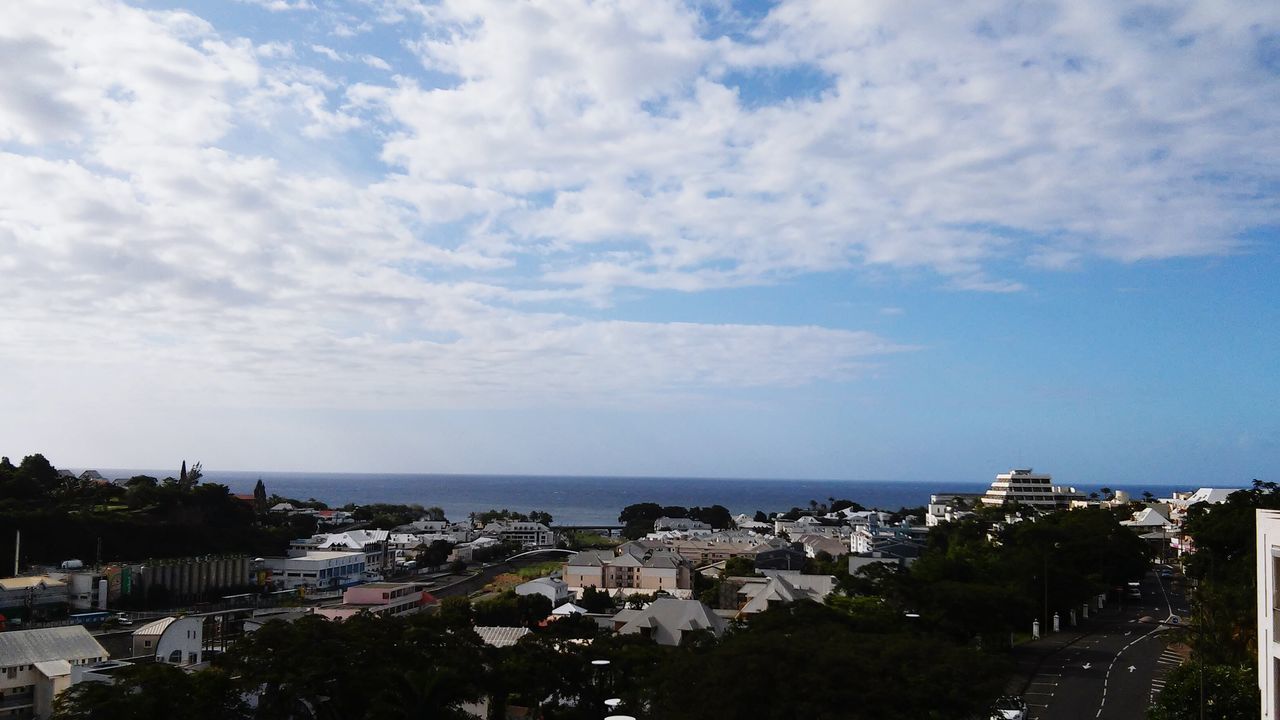 sky, sea, building exterior, architecture, built structure, horizon over water, water, cloud - sky, tree, high angle view, cloud, house, cloudy, nature, residential building, town, city, residential structure, scenics, residential district