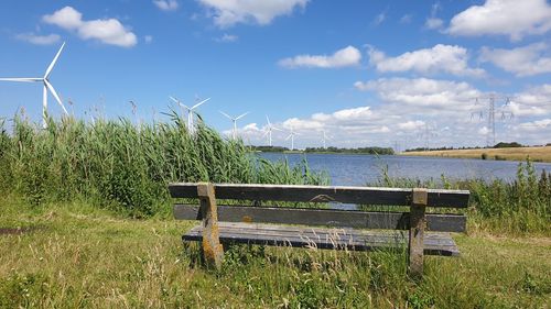 Bench on field against sky