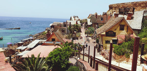 High angle view of townscape by sea against sky