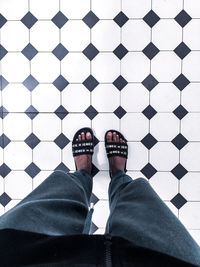 Low section of man standing on tiled floor