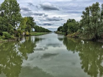 Scenic view of lake by trees against sky