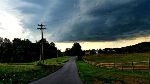 Country road against cloudy sky