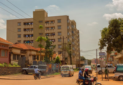 Cars on street in city against sky