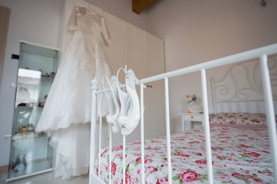 White sandals hanging n bed in bedroom at home