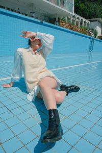 Low section of woman relaxing in swimming pool